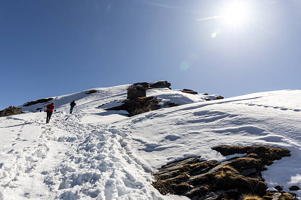 snowcap mountain peak with hiking trails and bright sky background at morning image is taken at chandrashila trek summit tungnath chopta uttarakhand india.